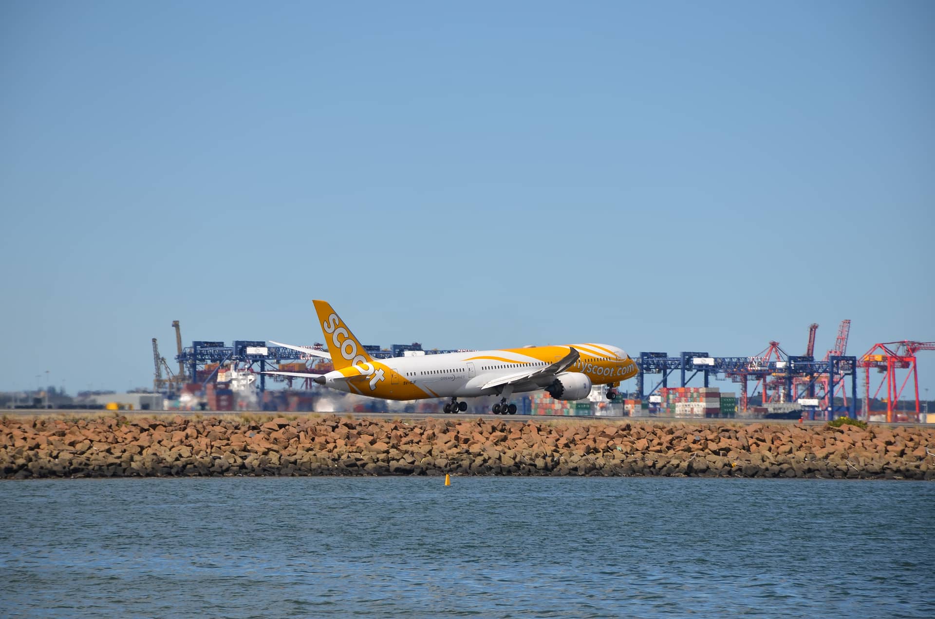 Scoot boeing 787 departing for singapore with port in the background – Australien, Australien und Ozeanien. Foto: Christian Böhme